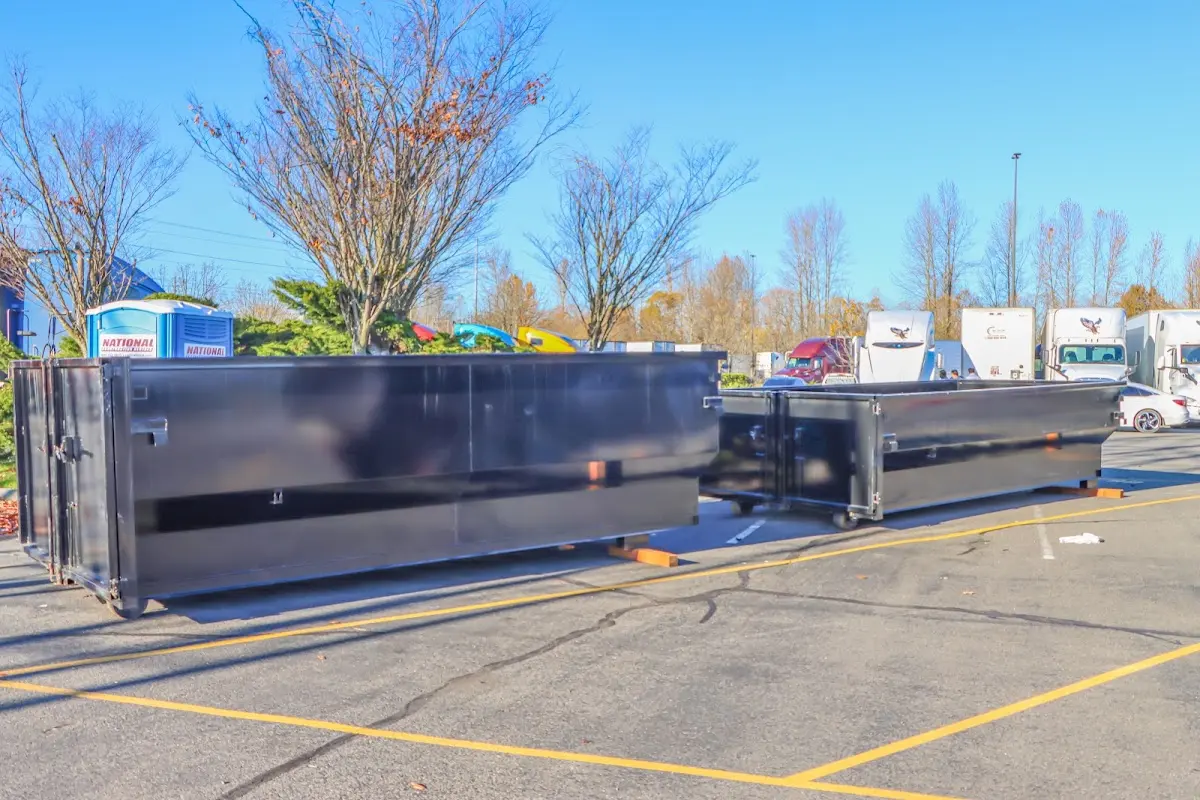 Professional dumpster rental service with roll-off container on residential driveway in Newstead